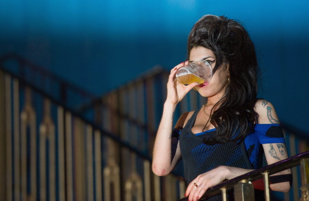 Amy Winehouse drinks a pint of lager as she watches The Libertines perform live at The Forum on August 25, 2010 in London, England.  